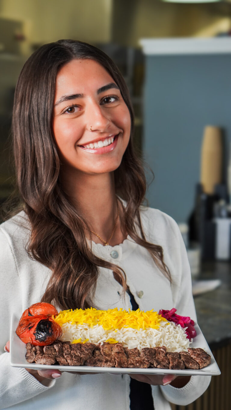Server presenting tenderloin kabob with saffron rice and grilled tomato at Linworth Grill